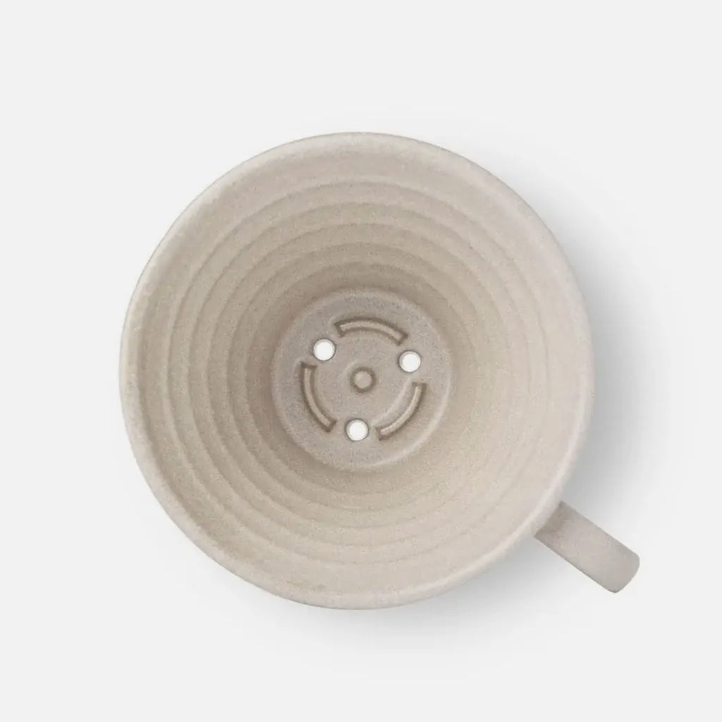Top view of beige Mino Kalita ceramic dripper showing concentric ridges and central filter holes.