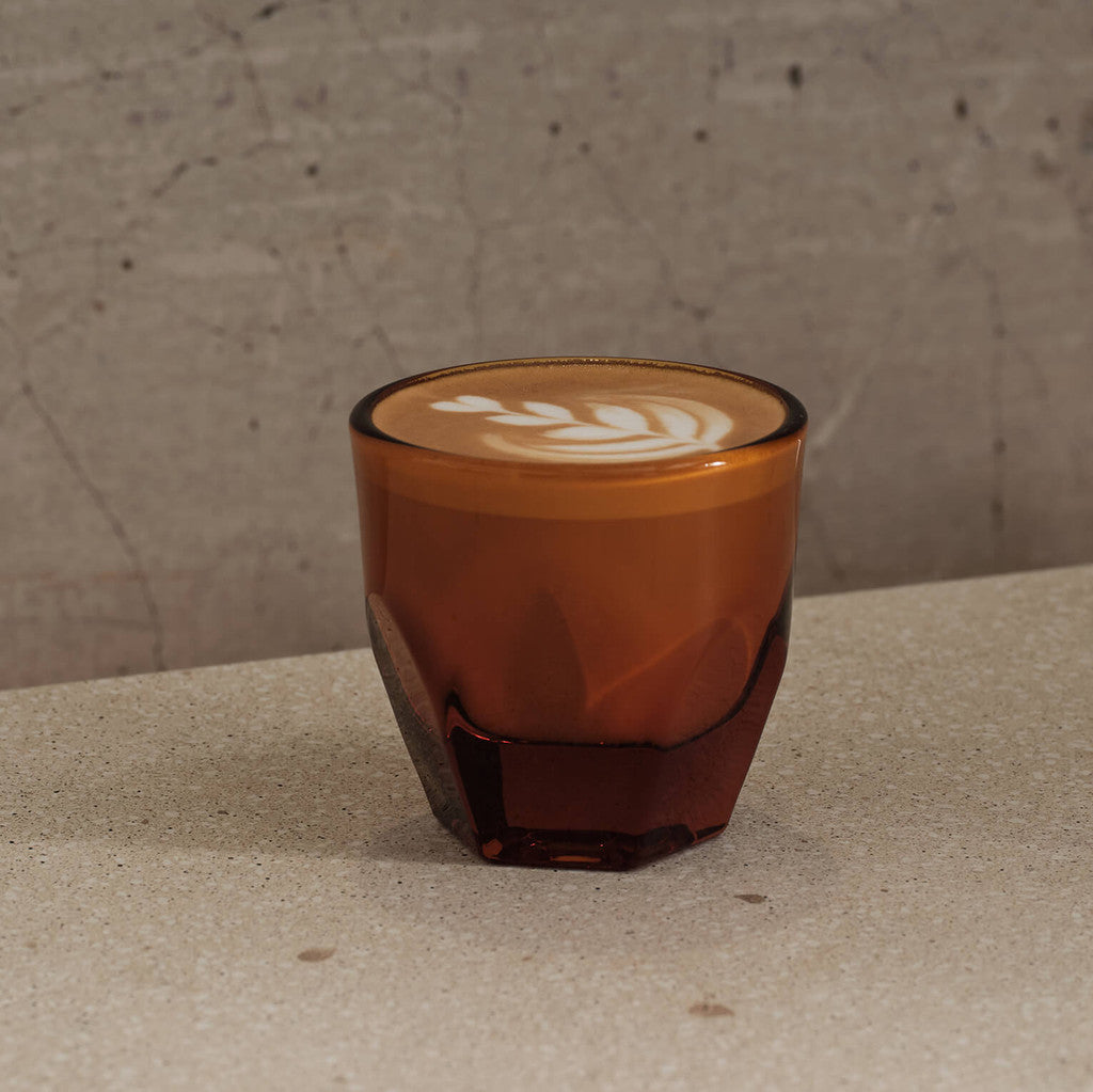 Amber heavy weight faceted Vero Cappuccino Glass shown filled with a cappuccino with latte art