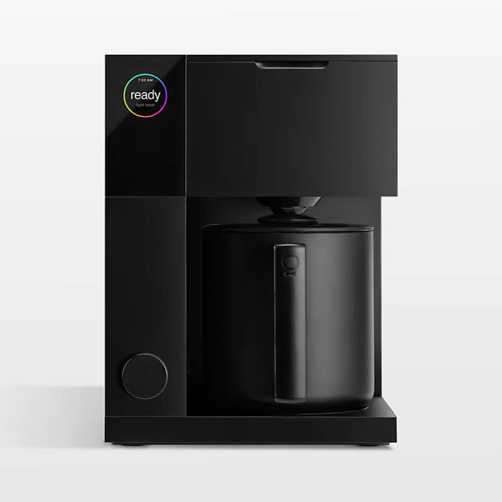 Matte black Aiden Precision coffee maker by Fellow with a carafe. The display screen is on the top left corner and a circular control dial on the bottom left of the machine.