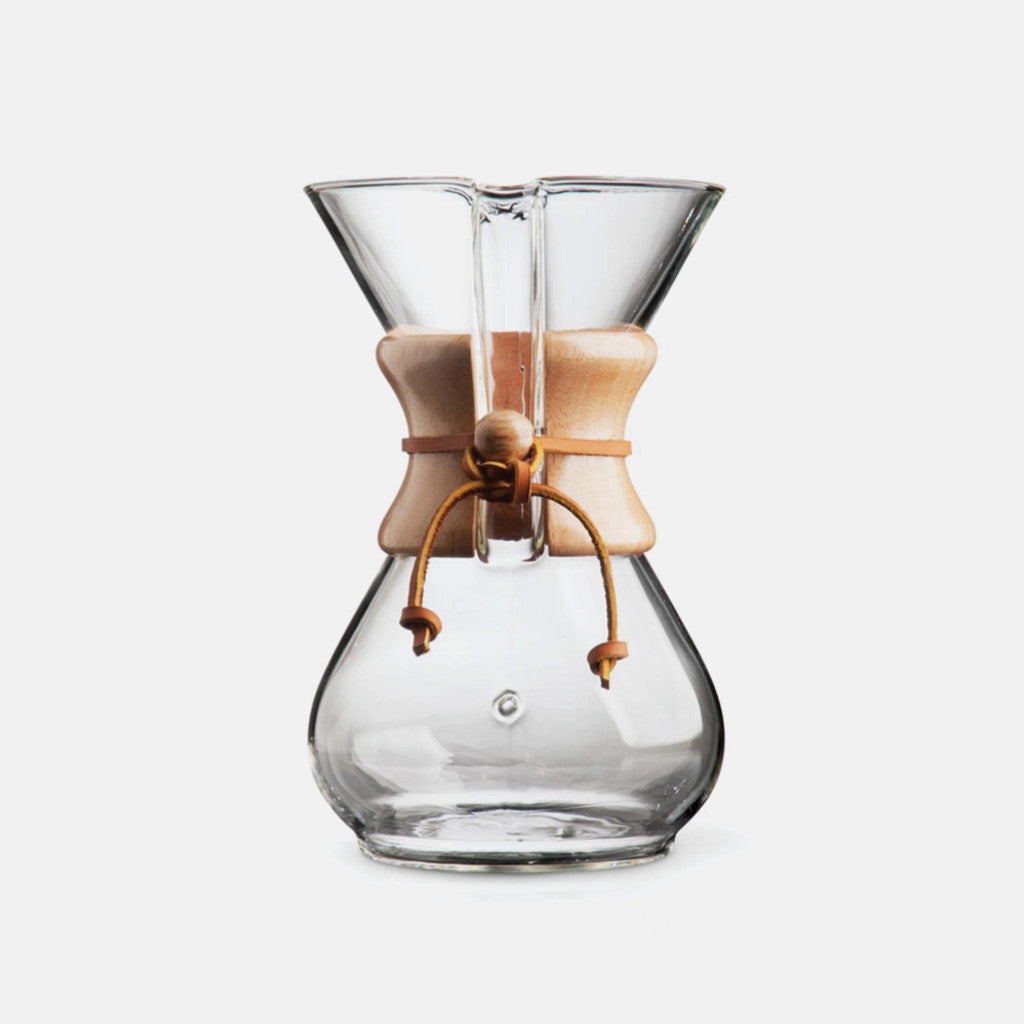 6 cup glass Chemex coffee dripper with light wooden collar and leather tie for pour over brewing.