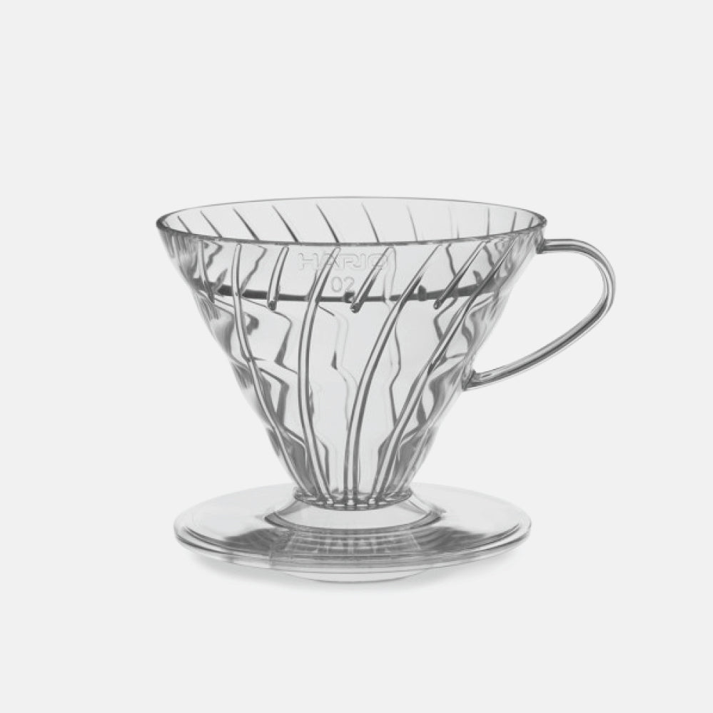 Clear resin V60 02 pour over coffee dripper with angled ribbed interior and side handle.