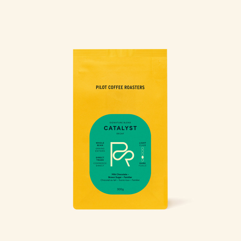Catalyst Decaf coffee bag with green label on bright yellow packaging standing upright.