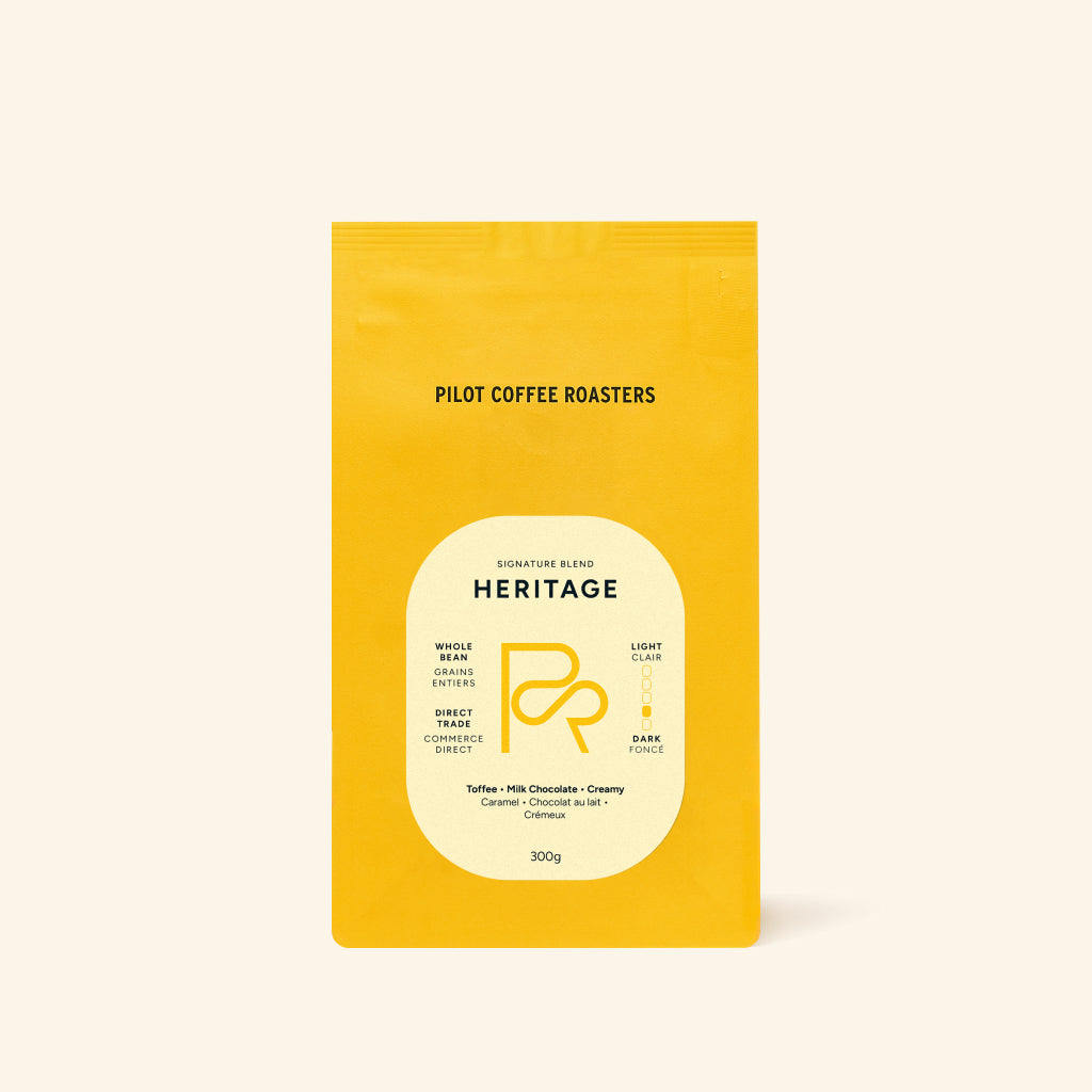 Yellow Heritage coffee bag centered on a cream backdrop with the Heritage label.