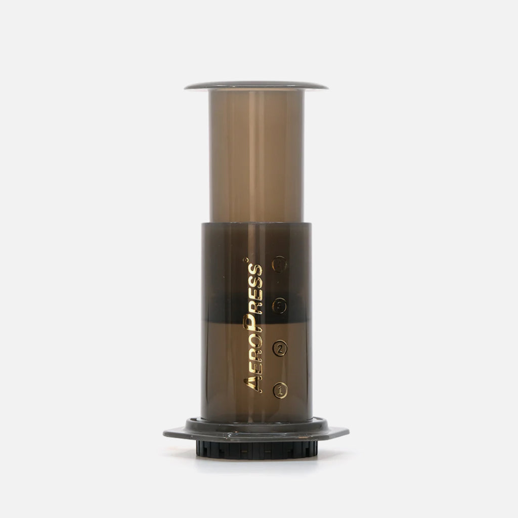 AeroPress Original coffee maker with plunger extended and brown translucent chamber with AeroPress wordmark logo.