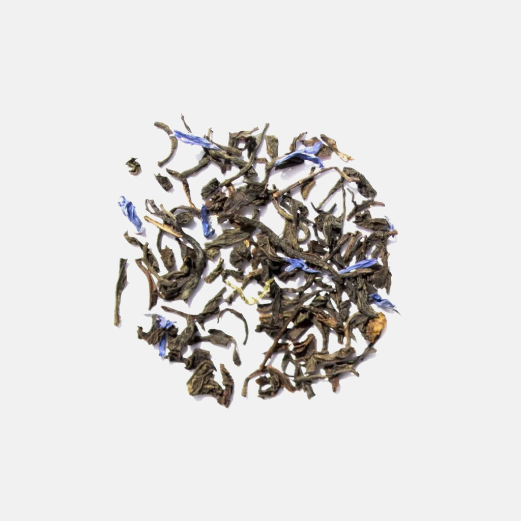 Cream of Earl Grey loose tea leaves with blue flower petals arranged in a circular pile.