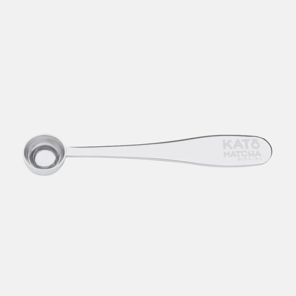 Stainless steel Katō Matcha scoop with long curved handle and logo on the end