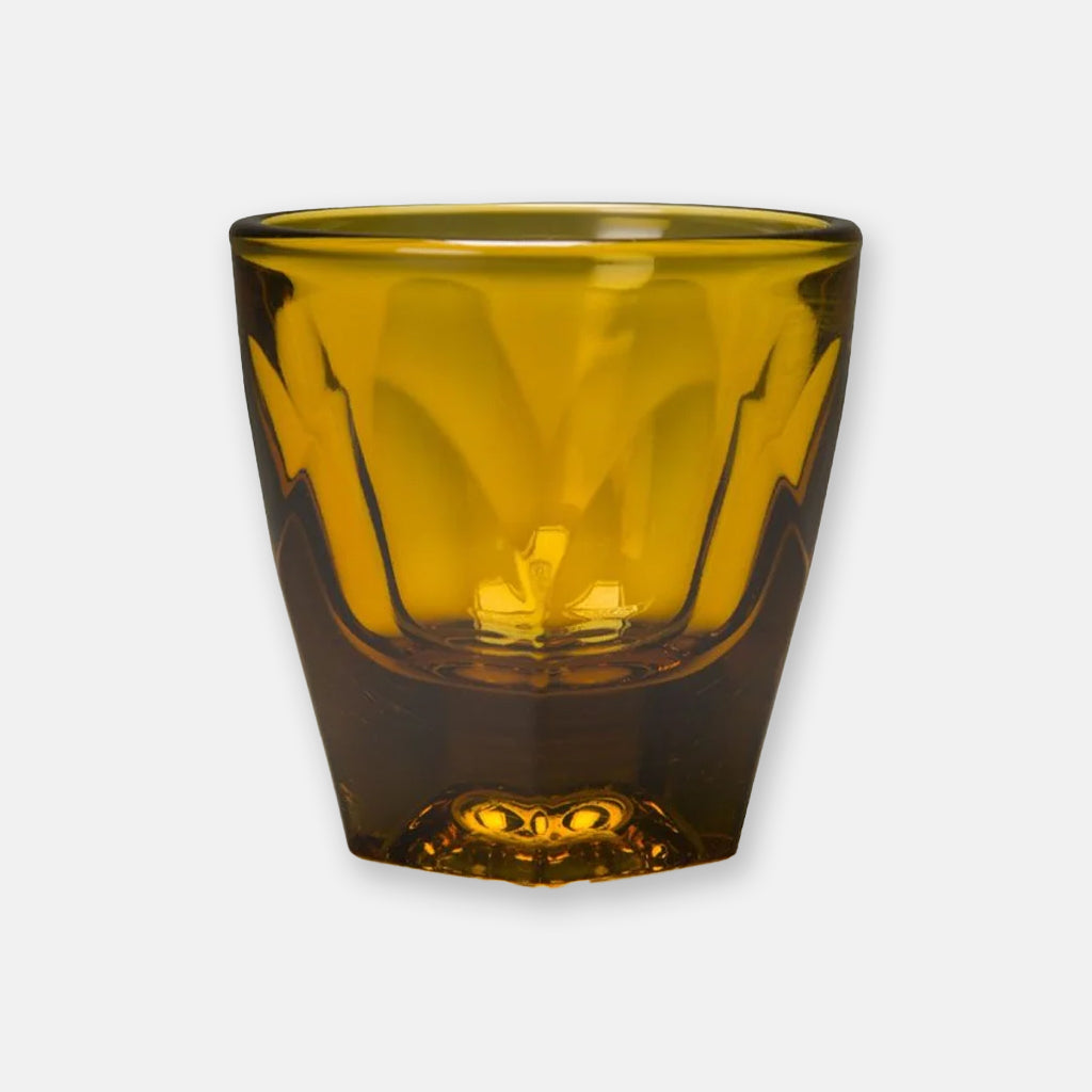 Cortado size, amber coloured faceted glass heavyweight tumbler with a chunky geometric silhouette and smooth rim.